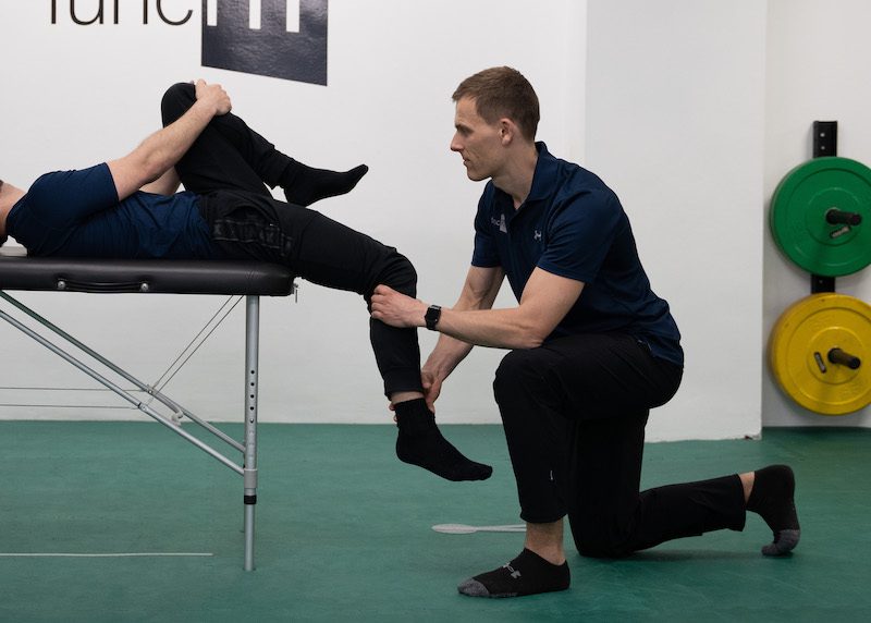 Testung der Hüftbeuger Beweglichkeit in Rückenlage (Thomas Test), um herauszufinden ob eine Dehnung bei chronischen Schmerzen helfen kann